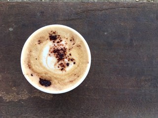 white paper cup of hot coffee on the wooden table