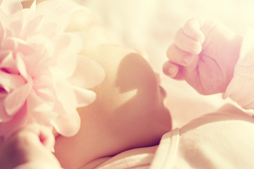 Little cute baby girl lies and sleeps in her bed, holding it hand on mouth. Beautiful sunlight. Horizontal.