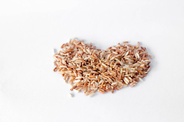 brown rice in heart shape isolated on white background