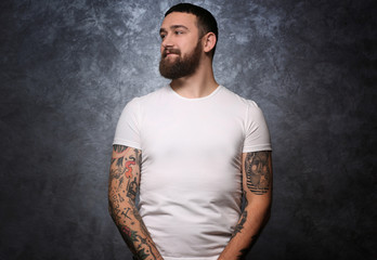 Portrait of tattooed man on gray background