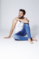 Happy guy in vest and jeans, looking away