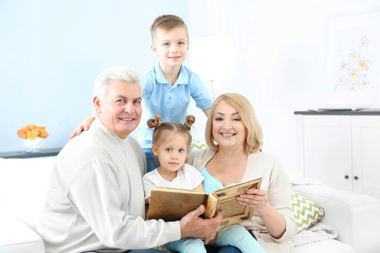 Grandparents looking at photo album with their grandchildren