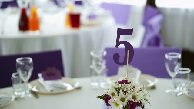 Flowers composition on table in restaurant with number five sign