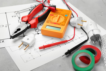 Electrician tools and schemes on grey background