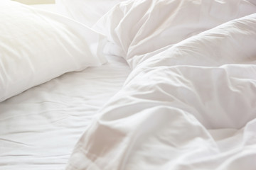 wrinkle messy blanket and white pillow in bedroom after waking up in the morning, details of duvet...