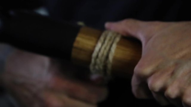 artisit applies twine to didgeridoo project
