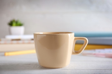 Blank ceramic cup on wooden table