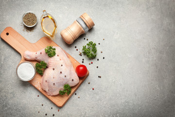 Fototapeta na wymiar Raw chicken thigh with spices on grey background