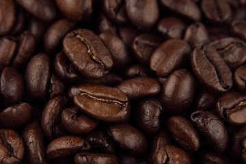 Roasted coffee beans closeup top view as background.