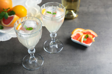Glasses with delicious wine spritzer on grey table