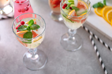 Glasses of delicious wine spritzer on grey table