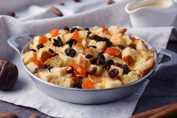 Tasty bread pudding with dried fruits on wooden table