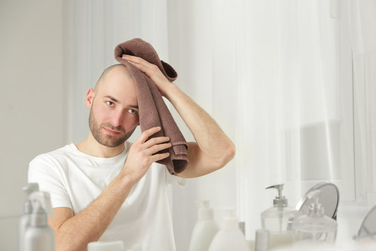 Hair loss concept. Young man looking at mirror