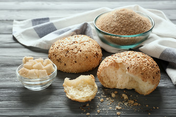 Buns with sesame and bread on wooden table
