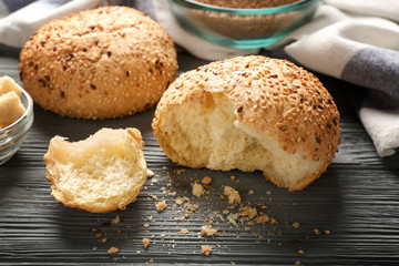 Buns with sesame and bread on wooden table