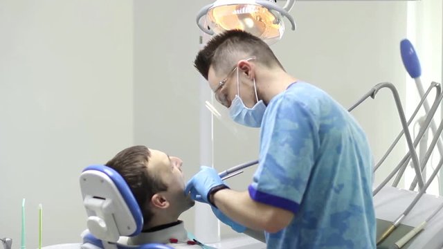 dentist treats tooth patient in the clinic