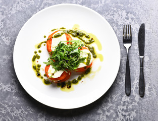 Tasty tomatoes sliced with mozarella cheese and green arugula salad