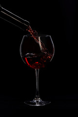 wineglass and bottle with wine isolated on black background