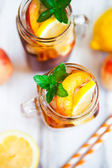 Homemade lemonade with ripe  peaches and fresh mint. Fresh peach ice tea on white wood table. Copy space background.