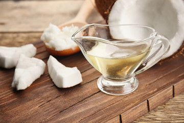 Coconut and kitchenware with fresh oil on wooden board