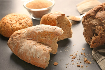 Bread crumbs and broken loafs on grey background