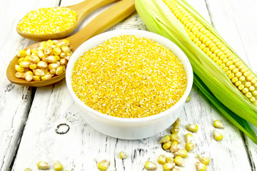 Corn grits in bowl with cobs on board