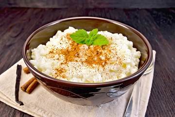 Rice porridge with cinnamon in bowl on napkin