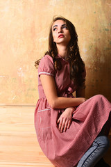Fototapeta premium pretty sexy woman in red checkered dress on beige background