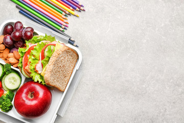 Delicious food and colorful pencils on light textured background