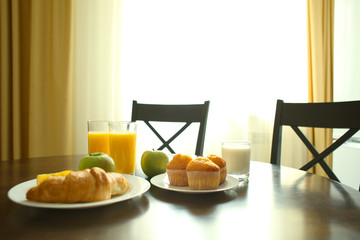 Delicious food on wooden round table in kitchen