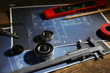 Different kinds of engineering tools and construction drawings on wooden background