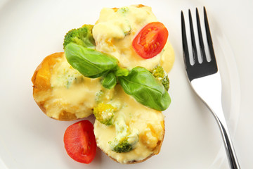 Portion of delicious baked potato with cheese sauce, closeup