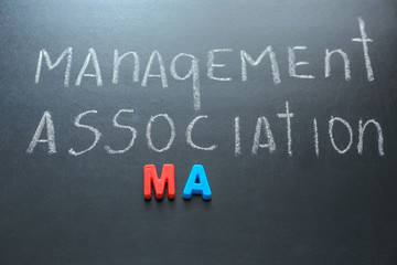 Abbreviation and text written with chalk on table. Management concept © Africa Studio
