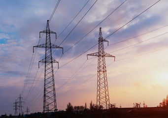 Silhouette of high voltage electrical pole. Sunset sky background.