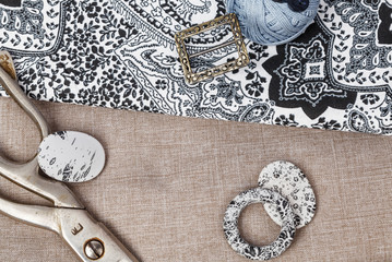 Scissors and buttons on grey pattern fabric