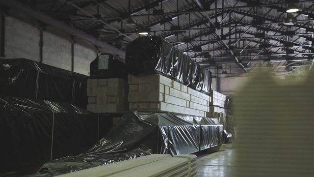 Engineered stress rating product made by bonding together separate pieces of wood, having a nominal thickness of 2 inches or less. Large hangar with a production line for wood.