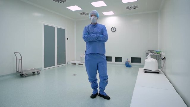 A man working in a clean room, pharmaceutical enterprise. Specialist in a protective suit, gloves, glasses and a mask.