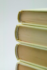 A pile of books on a table, all white; tilt-shift effect applied. Suitable to be used like a...