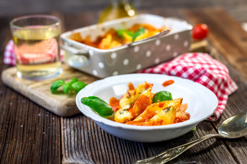 Stuffed pasta shells casserole with gorgonzola, ricotta and tomato sauce