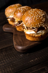 Homemade Mini Beef Burgers with Coleslaw Salad on Little Wooden Cutting Board. Barbecue Meat Sandwiches on Rustic Table.