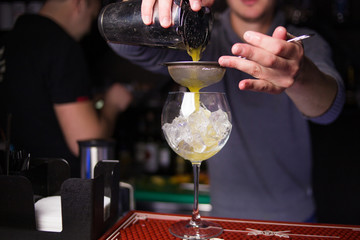alcoholic yellow cocktail is pours