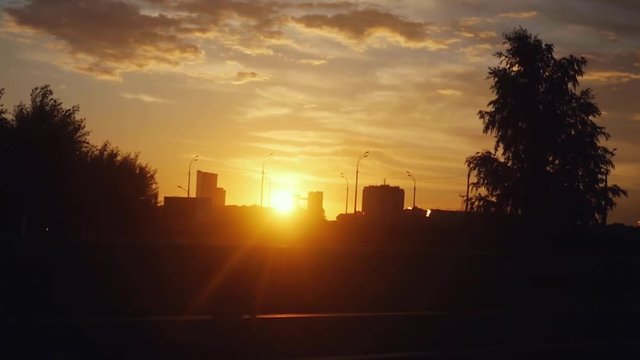 Amazing sunset view on the road in russian city on summer time with lense flare effects in slow motion. 1920x1080