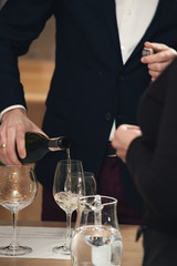 sommelier pouring wine into glass at wine tasting
