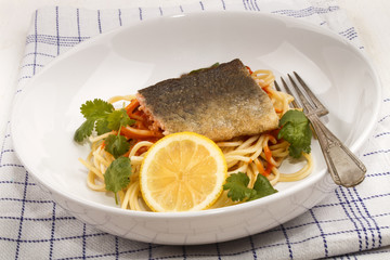 grilled trout fillet on spaghetti with tomato sauce