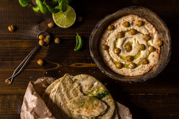 Homemade Chickpea Hummus in Rustic Bowl with Olive Oil and Fresh Pita Bread