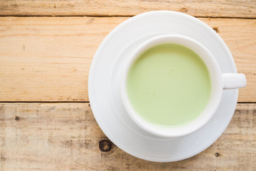 hot matcha latte on wood background.