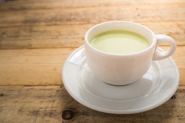 hot matcha latte on wood background.
