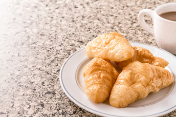 Breakfast with cup of coffee, croissant on the table.