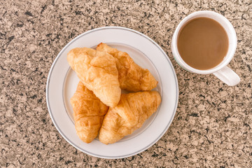 Breakfast with cup of coffee, croissant on the table.