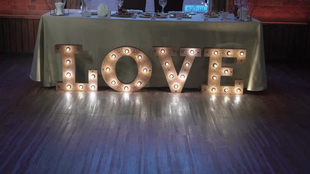 Restaurant decoration for wedding indoors - love sign made with lamps